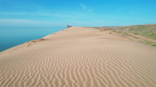 Desert Dune with Blue Sea at Sunrise