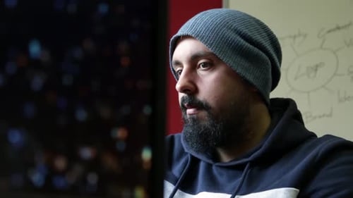 Der junge Designer arbeitet in seinem Büro vor einem Monitor und konzentriert sich auf ein Projekt, das abgeschlossen werden muss