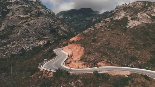 Cyclist riding fast downhill on road bicycle.