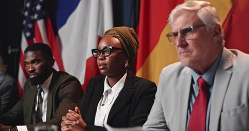 Adults at a Conference Table with National Flags