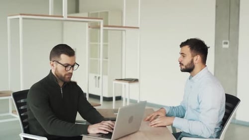 Male interview in bright office at table with laptop
