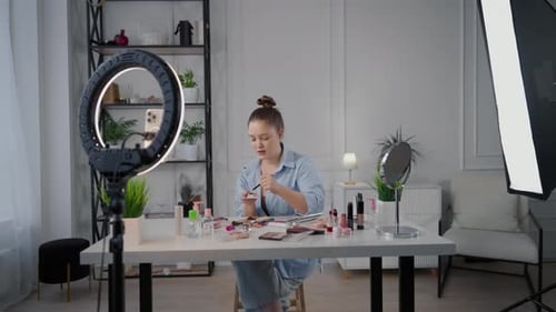 Mujer bloguera de belleza filmando una reseña sobre pinceles cosméticos en Home Studio Stream Influencer of Beauty