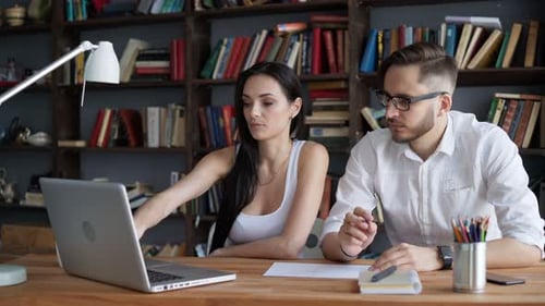 Two Students Brainstorming Work by Discuss with Desktop in Trendy Loft Close