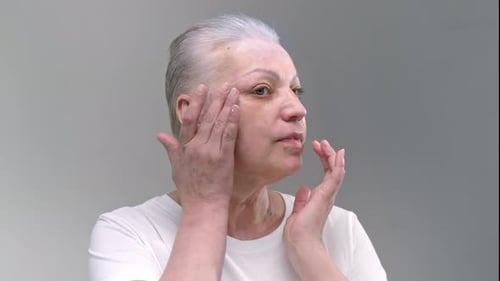Senior Woman Applying Cream to Her Face