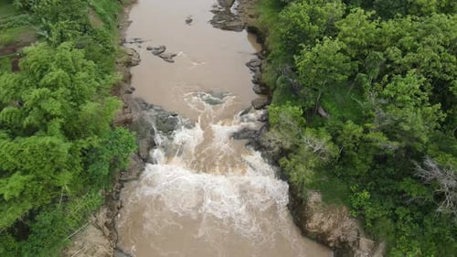 Luftbild, der Fluss fließt sehr schnell und das Flusswasser ist trüb.