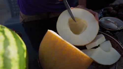 Un homme a coupé du melon jaune mûr en Ouzbékistan
