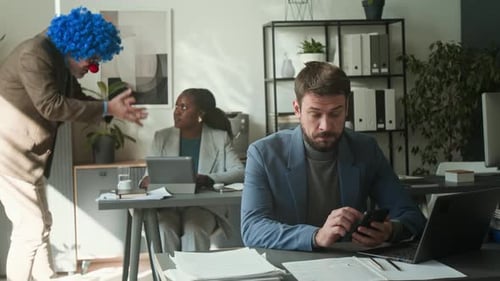 Angry Boss in Clown Wig and Nose Yelling at Employees during Office Workday