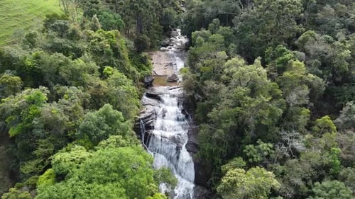 Aerial View of Tropical Waterfall Flowing Through Forest