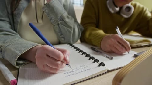 Studierende schreiben während der Vorlesung im Auditorium Notizen