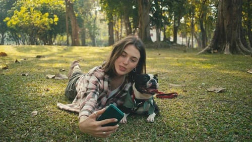 Woman Taking Selfie with Boston Terrier Dog in Park