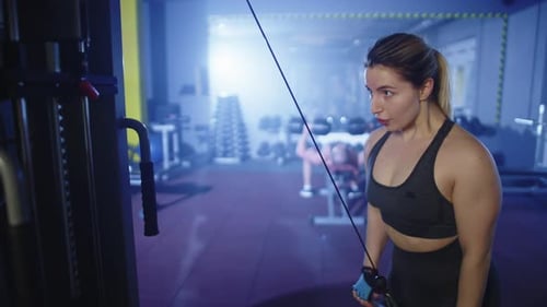 Woman Exercising on Cable Machine in Gym