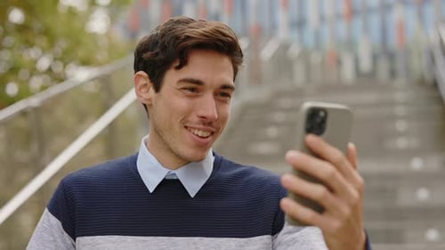 Positive Caucasian Office Worker Standing Using Smartphone Having Distant Meeting Waving at the
