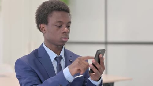 Young Adult Using Smartphone Wearing a Blue Suit