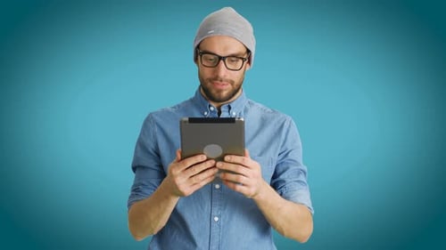 Man Using Tablet Against Blue Background