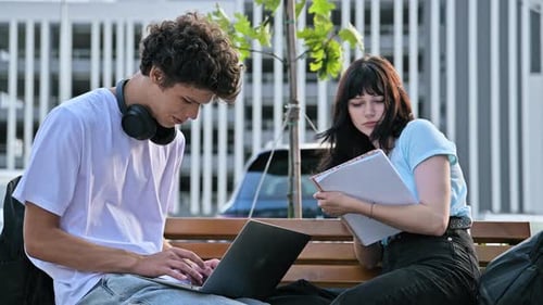 College Students Guy and Girl Studying Together Outdoors Using Laptop Notebooks