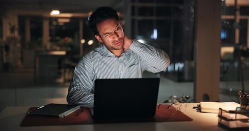 Man with Neck Pain Working Late at Computer