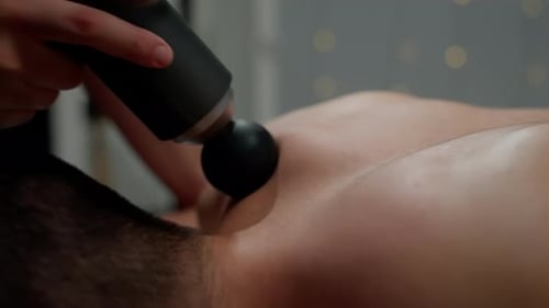 Man Receives Massage with Percussion Massage Gun