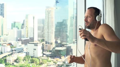 Excited Man Listening to Music in Urban Apartment