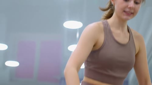 CloseUp of Girl Adjusting Posture During Gym Session with Instructor's Guidance
