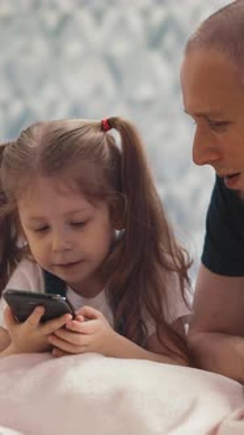 Child Using Smartphone with Father at Home