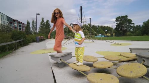 A Mother and Her Little Son Having Fun on the Playground