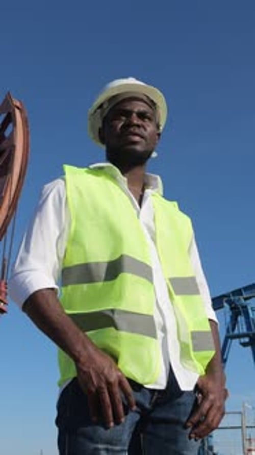 Industriestandortaufseher in weißem Helm untersucht Ölfeldbetrieb sorgfältig und vertraut auf schwarzen Standort