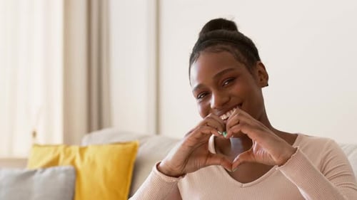 Smiling Woman Making a Heart with Hands