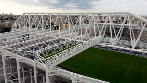 Aerial side fly shot outside an empty football stadium, building rig , drone shot, twilight.
