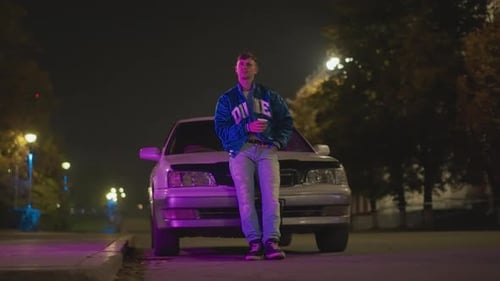 Nighttime Urban Scene Urban Nighttime Setting with Man on Phone Near Vehicle City Street Illuminated