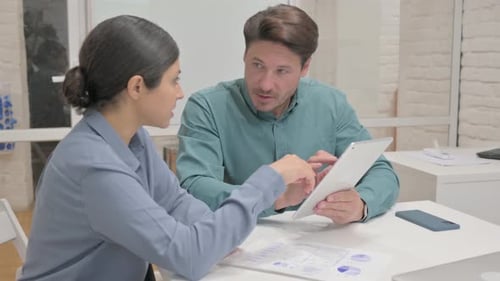 Business Professionals Collaborating on a Tablet in Office