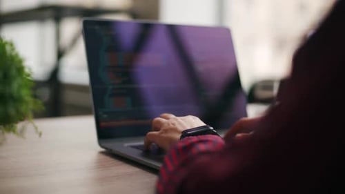 Nahaufnahme von Freelancers Händen, die Code auf der Laptop-Tastatur eingeben, rutscht um die des Entwicklers