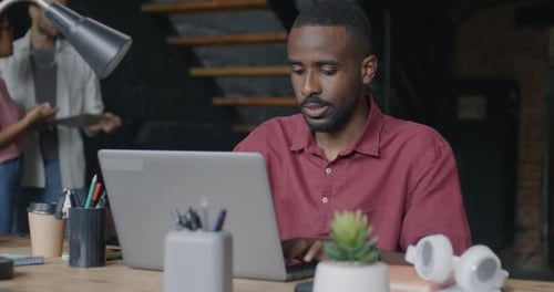 Man Working on Laptop in Modern Office