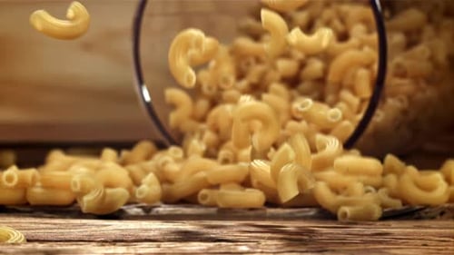 Dry Pasta Falls on a Wooden Table Filmed on a Highspeed Camera at 1000 Fps