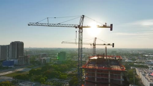 Tower Lifting Cranes at High Residential Apartment Building Construction Site Real Estate