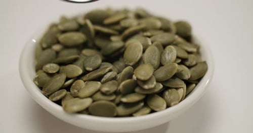 Close-Up of Pumpkin Seeds being Scooped with Spoon