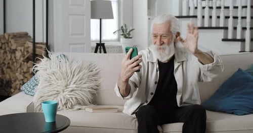 Crop View of Senior Grey Haired Man Waving and Smiling While Having Video Call Cheerful Male
