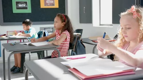 In school, children studying at desks in classroom, focusing on their work