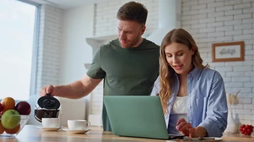 Couple Works on Laptop, Pours Coffee in Kitchen
