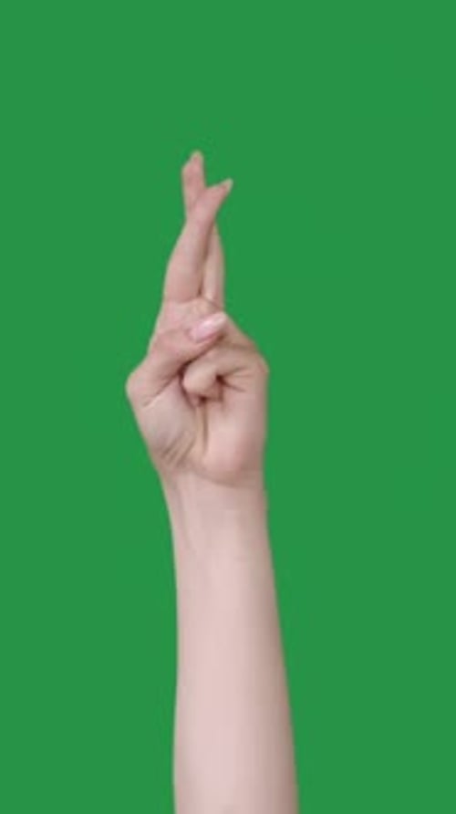 Hand Crossing Fingers Against Green Screen Background