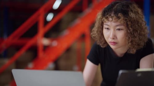 Concentrated warehouse worker uses a computer