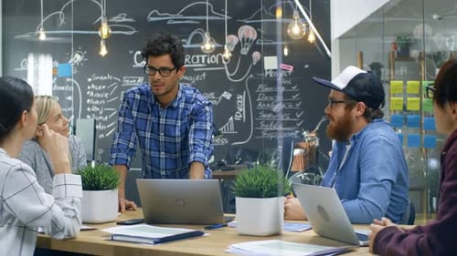 Team Brainstorming Collaboration Meeting at Table With Laptops
