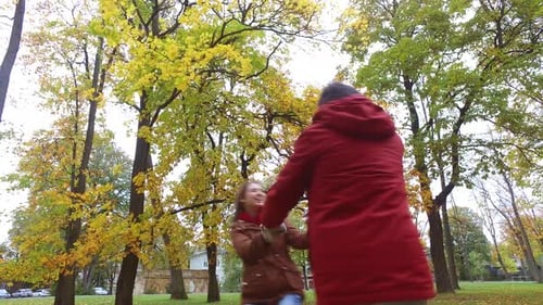 Happy young couple embracing and dancing in autumn park a beautiful fall day