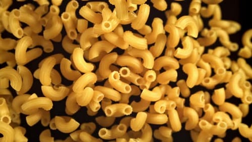 Macaroni Elbow Pasta Filling Frame on Dark Background