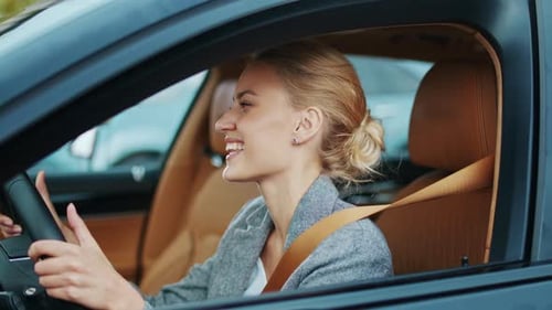 Woman Driver in Car Smiles and Adjusts Hair