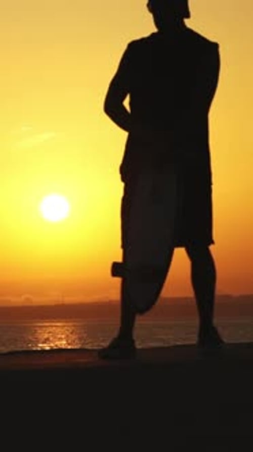 Silhouette of Skateboarder Enjoying a Beautiful Seaside Sunset