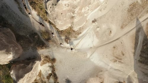 Topdown Shot Of Tourist's Horse Trekking Through Cappadocia Landscapes In Turkey. Aerial Shot
