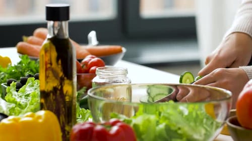Junge Frau bereitet zu Hause gesunden Salat zu