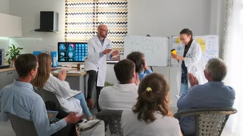 Medical professionals at a conference clapping for colleague