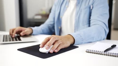 Close up of man's hand holding a computer mouse. Young adult african american businessman working