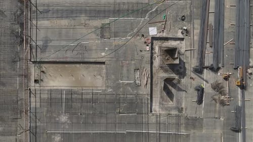 Trabajadores de vista aérea preparando los cimientos y dando forma a las barras de refuerzo en la construcción